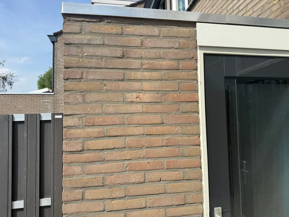 Hoek van een bakstenen gevel met strak voegwerk