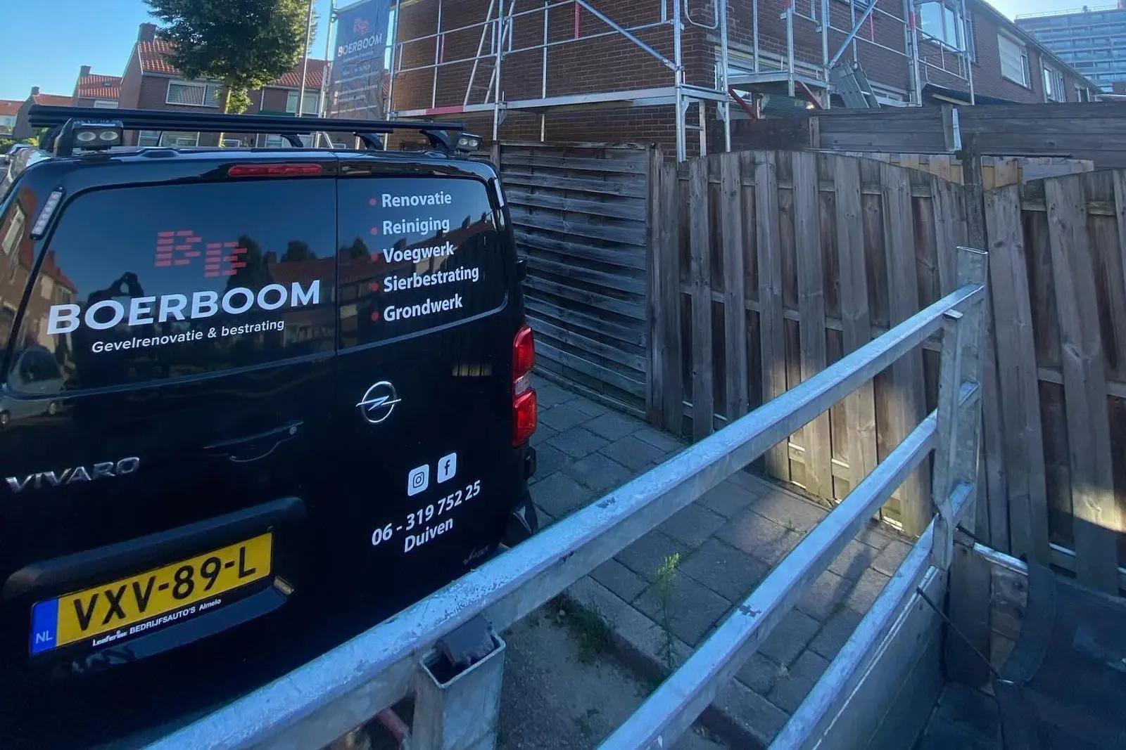 De zwarte bus van Boerboom voor een woning in de steigers in Duiven, tijdens een gevelrenovatie