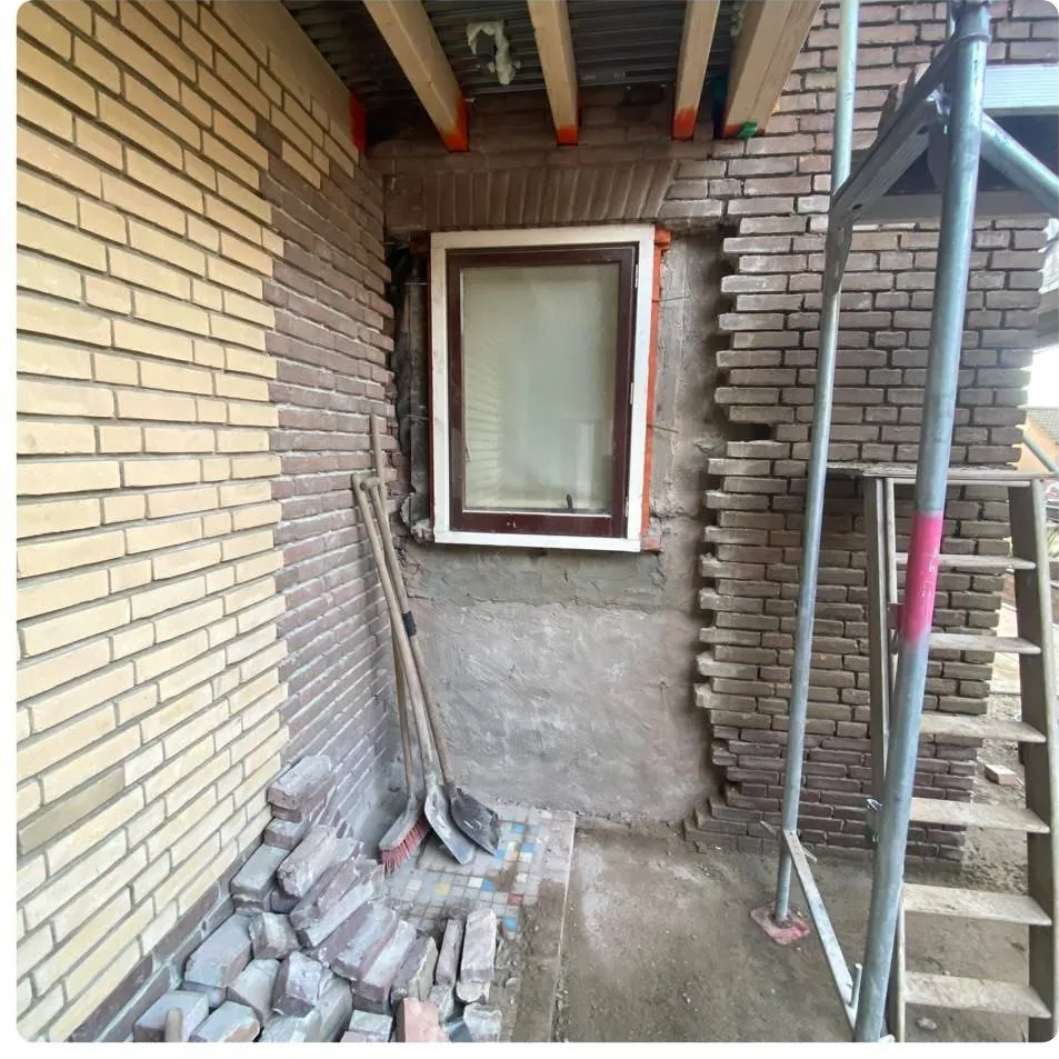 Metselwerk rond een kozijn uitgehakt, klaar voor herstel