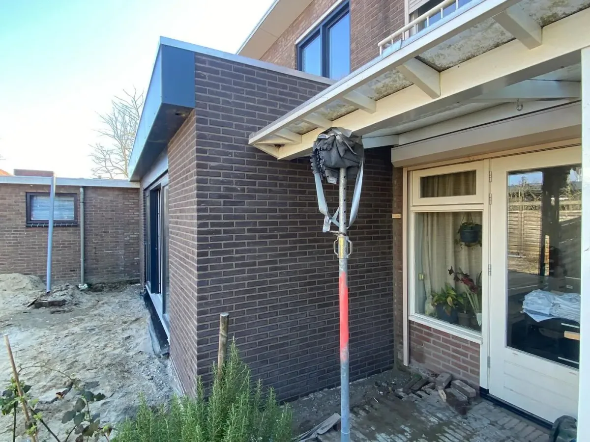 Nieuwe aanbouw met vers voegwerk aan een bestaande woning