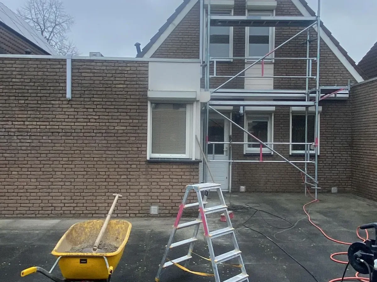 Achtergevel met steiger en een ladder, klaar voor voegwerk