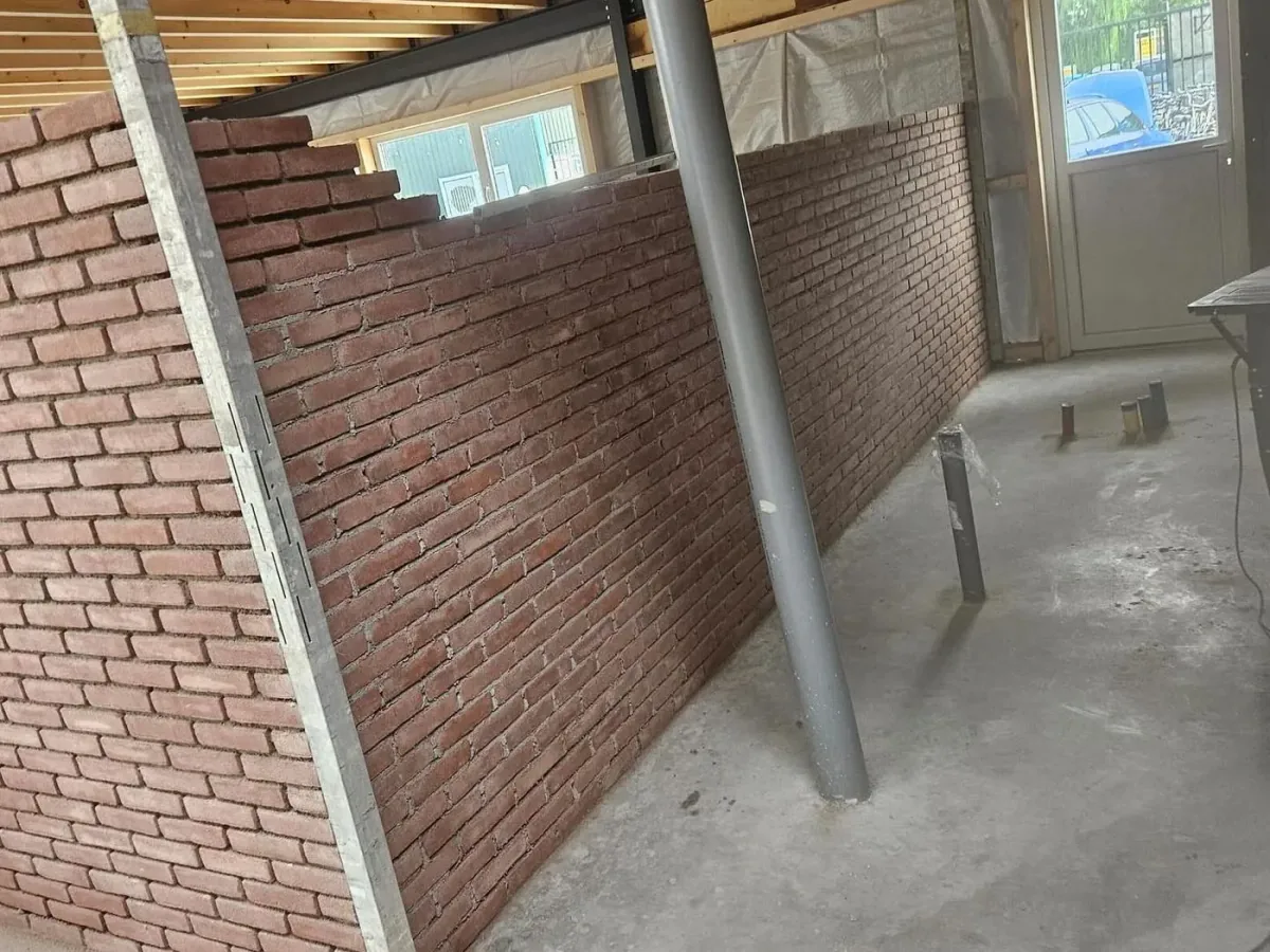 Nieuwe bakstenen muur in een kantine in aanbouw