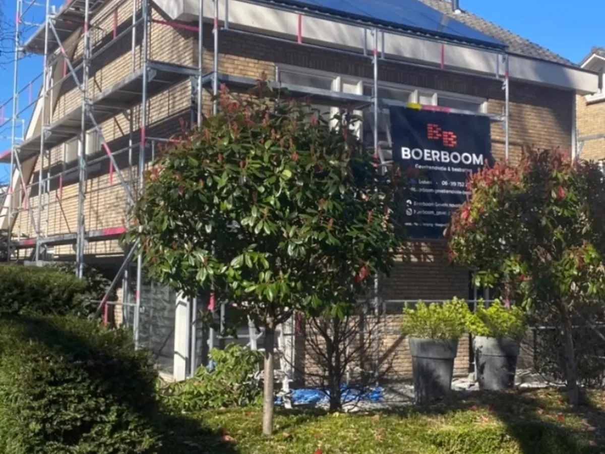 Woning in de steigers met het bord van Boerboom, tijdens een gevelrenovatie