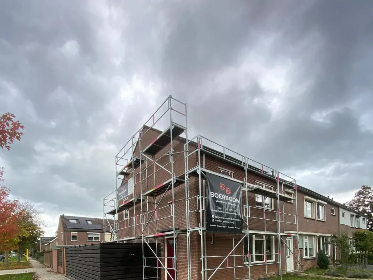 Hoekwoning in de steigers naast een tegelpad en een grasveld
