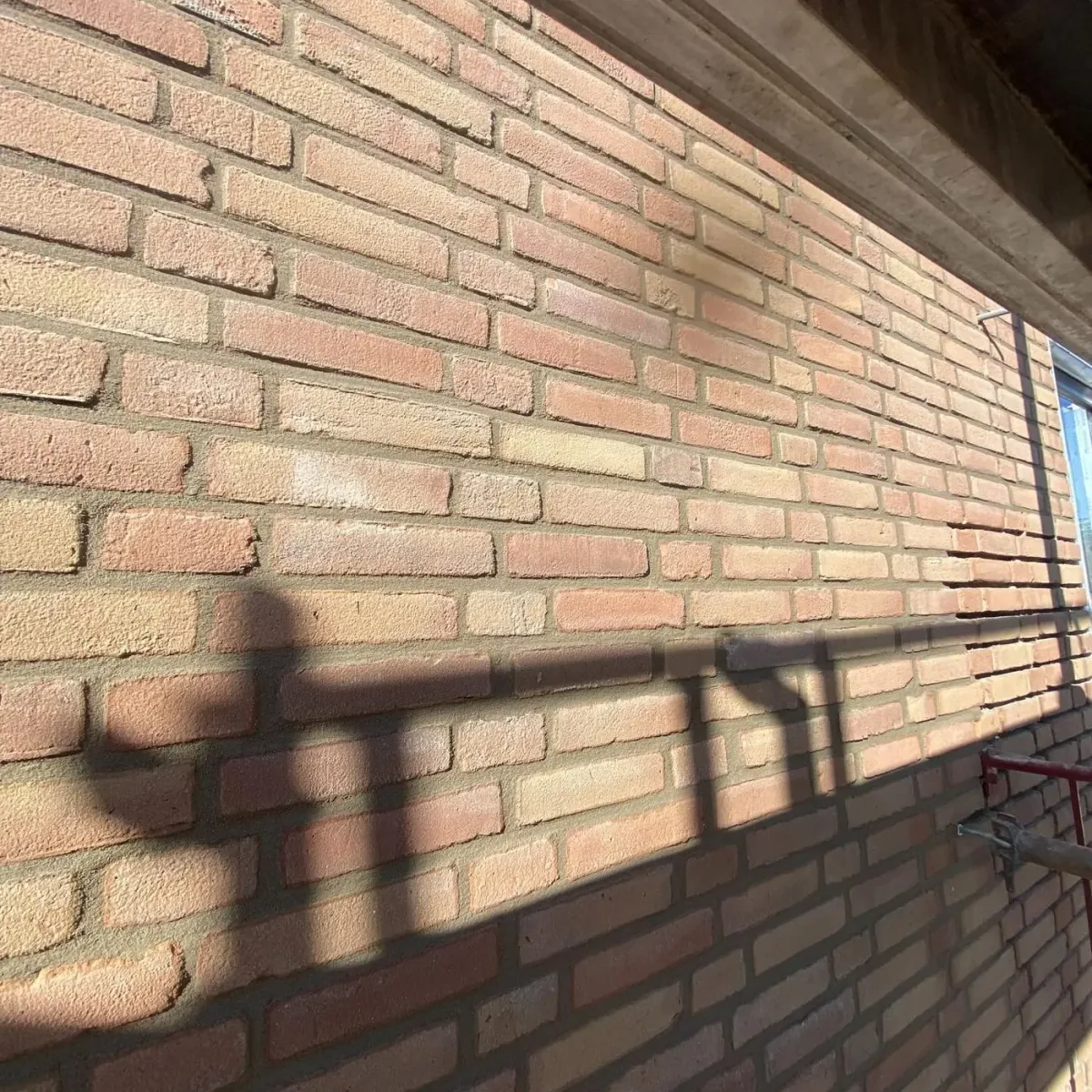 Vers voegwerk in een lichte bakstenen gevel
